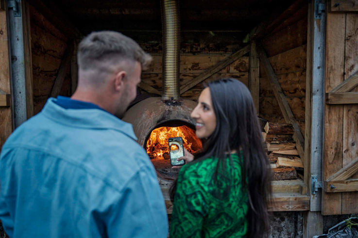 Couple taking videos of Slemish Market Supper Club's woodfire oven